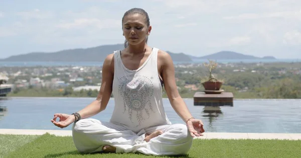 Señora practicando yoga en pose de loto frente a la costa oceánica —  Fotos de Stock