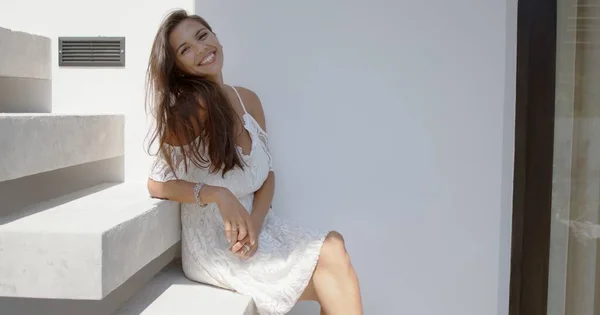 Iloinen nuori nainen istuu portaissa — kuvapankkivalokuva