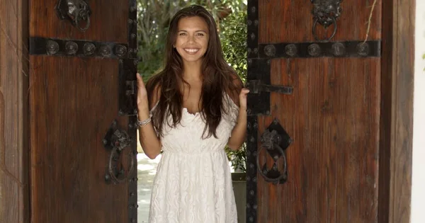 Cheerful woman opening old wooden doors — Stock Photo, Image