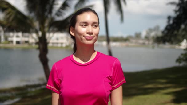 Veselá mladá žena stojící na břehu jezera — Stock video
