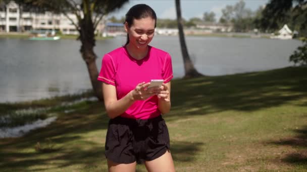 Спортивная женщина читает смешные сообщения на смартфоне — стоковое видео