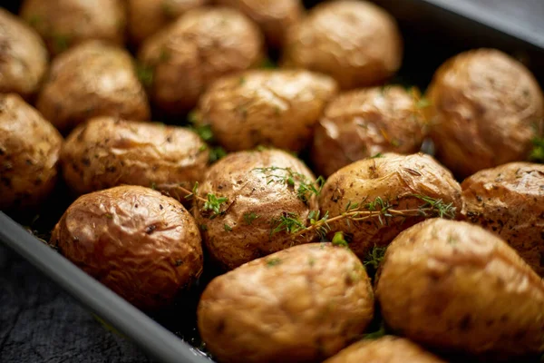 Fechar em caseiro assado batatas inteiras em jaquetas. Com manteiga, alecrim e tomilho . — Fotografia de Stock
