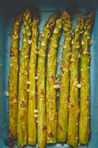 Gros plan sélectif sur les asperges rôties assaisonnées de sel, poivre, ail . — Photo