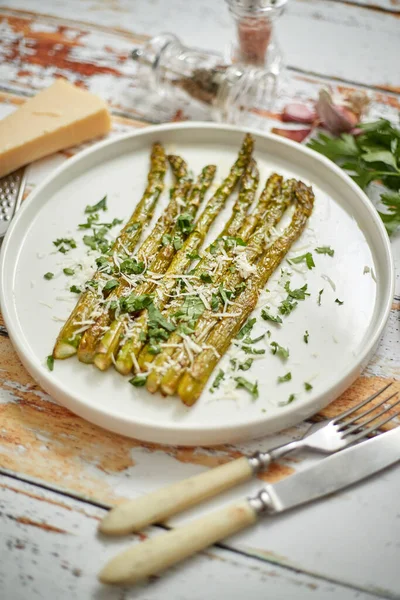 Espargos assados com queijo parmesão e salsa. Conceito de comida saudável primavera. Vista de cima . — Fotografia de Stock