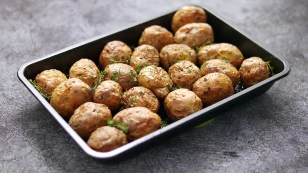 Hausgemachte gebratene ganze Kartoffeln in Jacken. Mit Butter, Rosmarin und Thymian. Serviert in metallischer Schale — Stockvideo