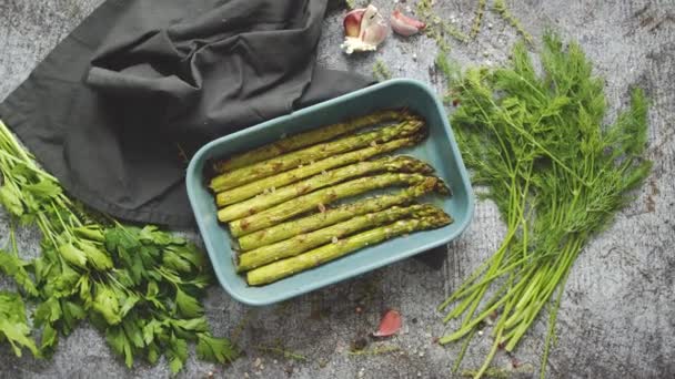 Espárragos asados sazonados con sal, pimienta, ajo y decorados con hierbas frescas — Vídeos de Stock