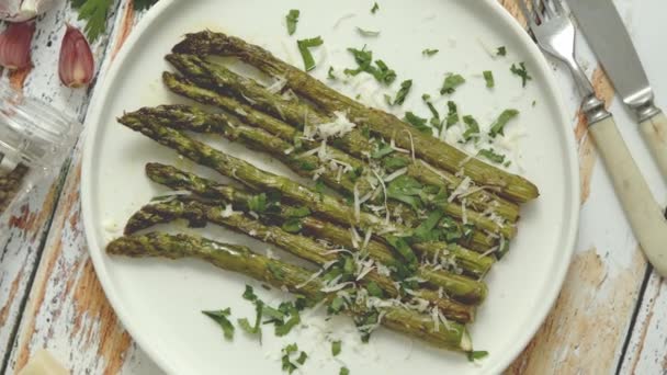 Gebraden asperges met parmezaanse kaas en peterselie. Gezond voorjaarsvoedsel concept. Uitzicht van bovenaf. — Stockvideo