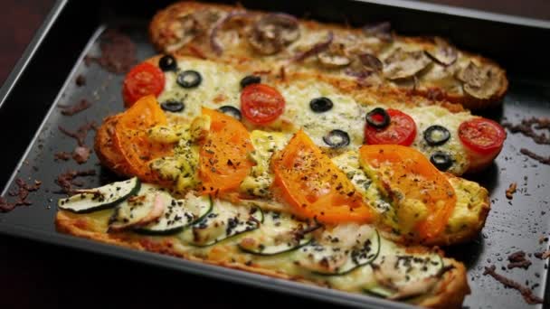 Deliziose baguette di panini caldi cotte con tonno, formaggio, pomodori, olive, zucchine e funghi — Video Stock
