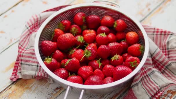 Vers geoogste aardbeien. Metalen vergiet gevuld met sappige verse rijpe aardbeien op een tafel — Stockvideo