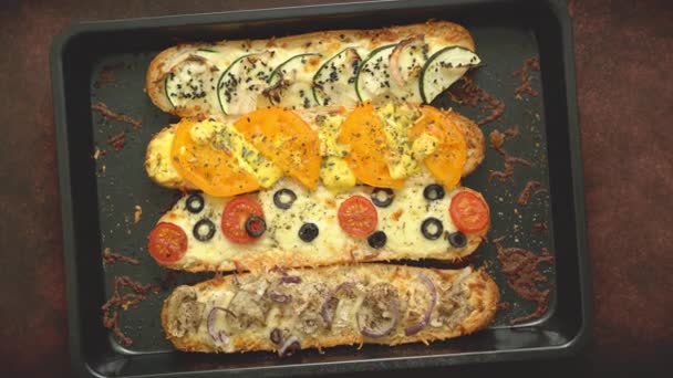 Deliziose baguette di panini caldi cotte con tonno, formaggio, pomodori, olive, zucchine e funghi — Video Stock