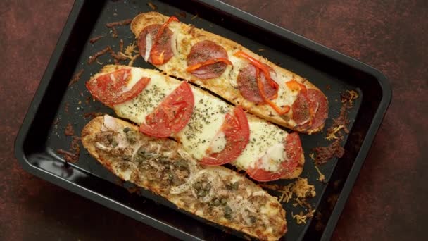 Deliciosas baguetes de sanduíche quente assadas com atum, queijo, tomate, azeitonas, courgette e cogumelos — Vídeo de Stock