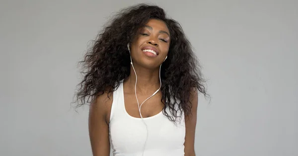 Mujer negra escuchando música y sonriendo —  Fotos de Stock