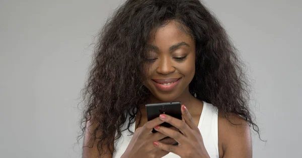 Χαρούμενη Αφροαμερικανή γυναίκα που χρησιμοποιεί smartphone — Φωτογραφία Αρχείου