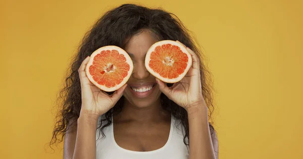 Aufgeregte ethnische Frau spielt mit Grapefruit — Stockfoto