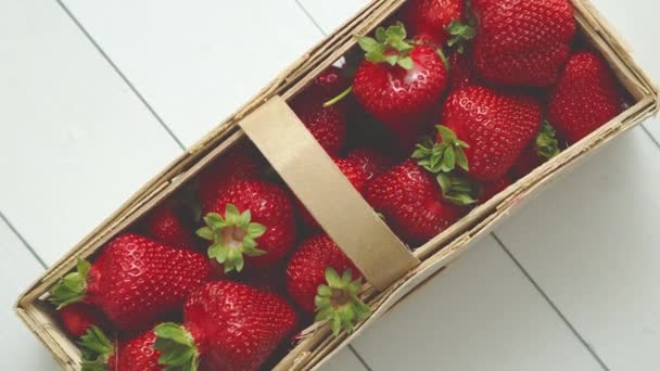 Houten container met verse rode aardbeien. Op witte tafel geplaatst. — Stockvideo