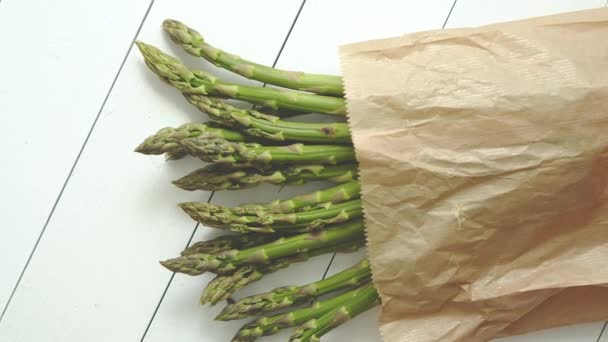 茶色の紙袋に新鮮な緑のアスパラガス。健康的な食事の概念。菜食主義者向け食品 — ストック動画
