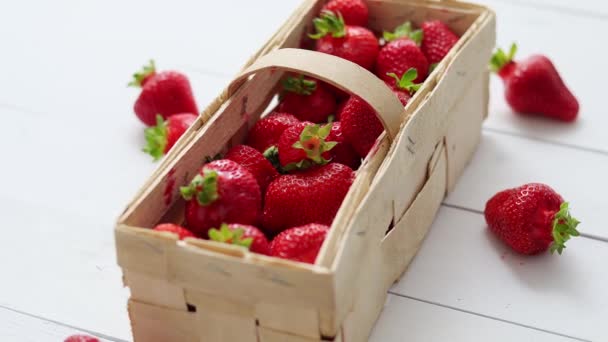 Contenitore in legno con fragole rosse fresche. Posizionato su tavolo bianco. — Video Stock