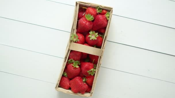 Świeże zdrowe truskawki w drewnianym pudełku na białym tle. — Wideo stockowe