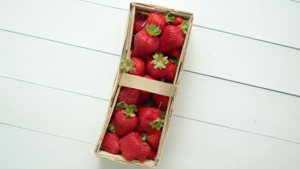 Fraises fraîches et saines dans une boîte en bois sur fond blanc. — Video