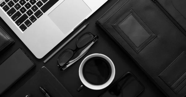 Concept de bureau professionnel. Mélange de fournitures de bureau et de gadgets sur fond de table noire — Photo