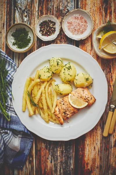 Färsk och välsmakande bakad lax serverad med ung kokt potatis och gul böna. — Stockfoto