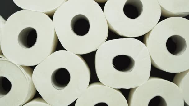 Rolos de papel higiénico colocados sobre fundo preto — Vídeo de Stock