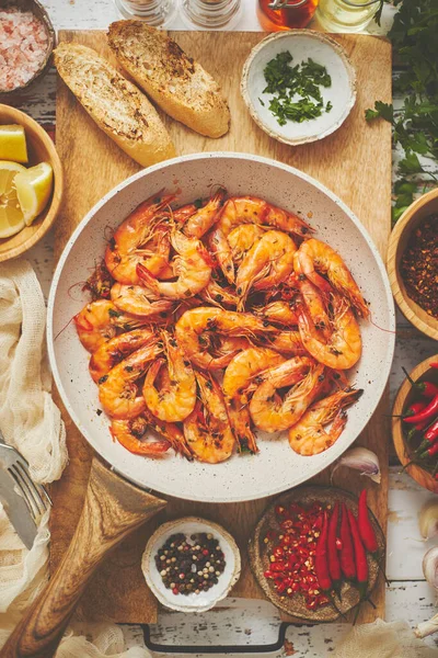 Traditional fried tiger prawn with garlic bread as top view served in a white frying pan — Stock Photo, Image