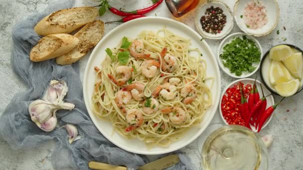 Espaguetis con gambas en plato de cerámica blanca y servido con copa de vino blanco — Vídeo de stock