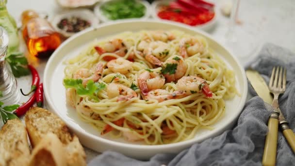 Spaghetti con gamberetti su piatto di ceramica bianca e serviti con bicchiere di vino bianco — Video Stock