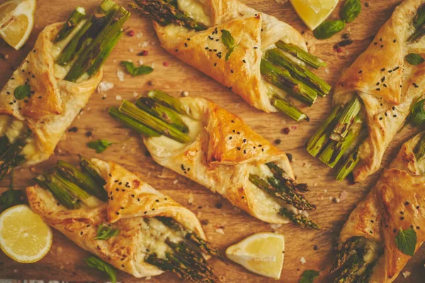 Asperges vertes grillées et pâte feuilletée au fromage pliée en enveloppe et garnie de sésame noir — Photo