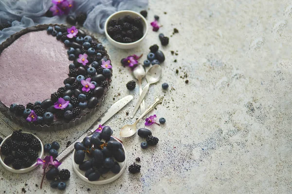 Crostata dolce e gustosa con mirtilli freschi, more e uva, servita su fondo pietra — Foto Stock