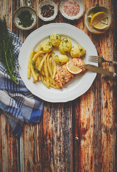 Färsk och välsmakande bakad lax serverad med ung kokt potatis och gul böna. — Stockfoto