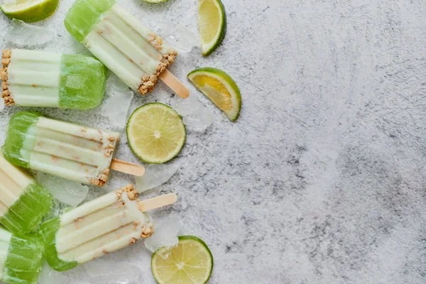 Lime och grädde hemmagjord glass eller glass placeras med isbitar på grå sten bakgrund — Stockfoto