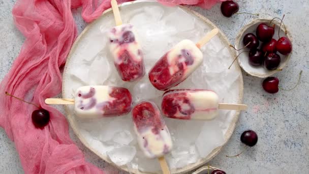 Świeża śmietana i domowe lody wiśniowe umieszczone na białej płycie ceramicznej z owocami i tkaninami — Wideo stockowe
