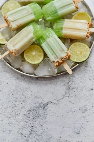 Cal y crema helados o helados caseros colocados con cubitos de hielo sobre fondo de piedra gris — Foto de Stock