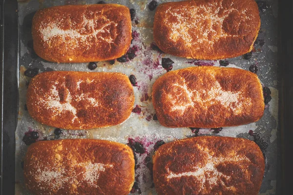 Délicieux petits pains chauds faits maison farcis aux myrtilles sur une plaque à pâtisserie — Photo