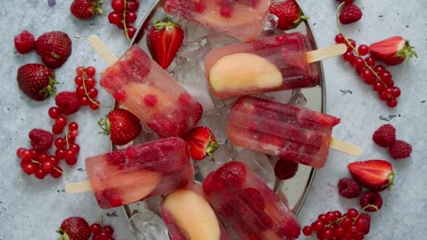 Frambuesa casera, fresa, manzana y paletas de grosella en plato de metal con bayas surtidas de hielo — Vídeos de Stock