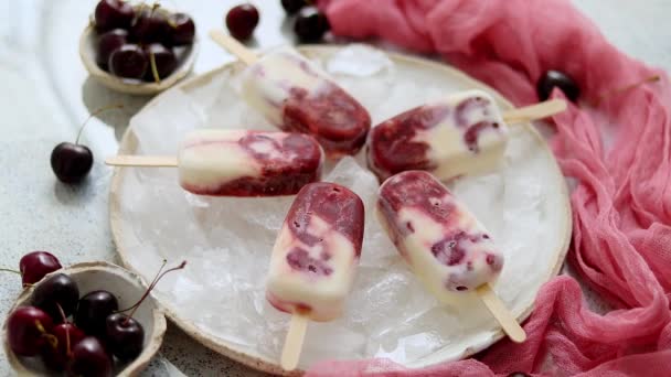 Ghiaccioli freschi alla panna e ciliegia fatti in casa posti su piatto di ceramica bianca con frutta e tessile — Video Stock