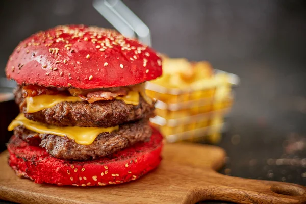 Buatan sendiri roti wijen bun burger double bacon cheese. Disajikan dengan kentang goreng di papan kayu. — Stok Foto