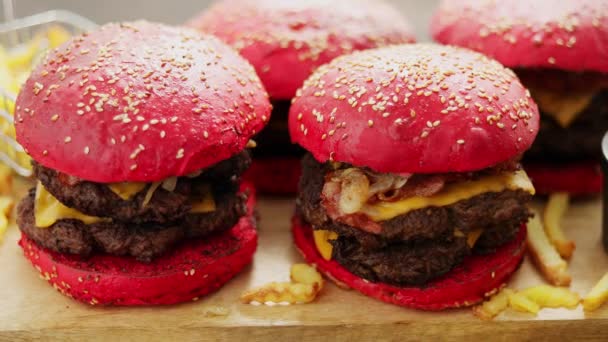 Dört adet ev yapımı dev çift Becon peynirli burger seti. Tahtada patates kızartmasıyla servis ediliyor.. — Stok video