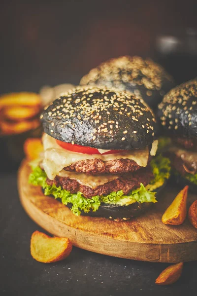 Black Double Burgers com queijo. Hambúrgueres de queijo do Japão com pão preto no fundo escuro — Fotografia de Stock