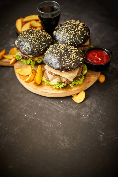 Delicioso hambúrguer preto com rissóis e queijo — Fotografia de Stock