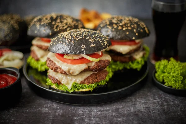 Delicioso hambúrguer preto com rissóis e queijo — Fotografia de Stock