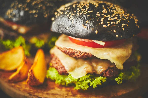 Köstliche schwarze Hamburger und Kartoffelchips — Stockfoto