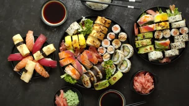 Festival de comida asiática. Menú de sushi con nigiri, maki, uramaki en platos negros. Varios tipos de sushi — Vídeos de Stock