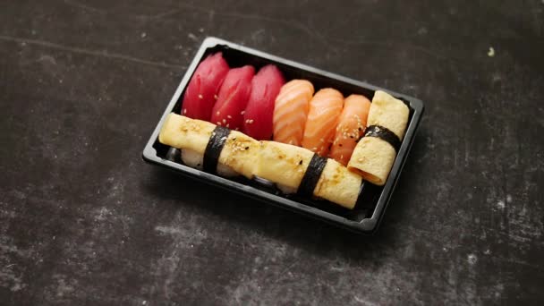 尼吉里寿司装在塑料容器中，随时可供外卖。把饭盒拿走的衣物 — 图库视频影像