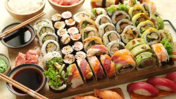 Nad pohledem na různé sushi a role umístěné na dřevěné desce. Japonské jídlo fest — Stock video