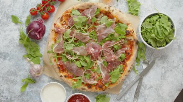 Pizza z prosciutto i rukolą. Podawany ze świeżymi składnikami po bokach — Wideo stockowe