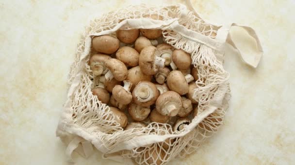 Young fresh Champignons in a ecological zero-waste net bag placed on beige background — Stock Video