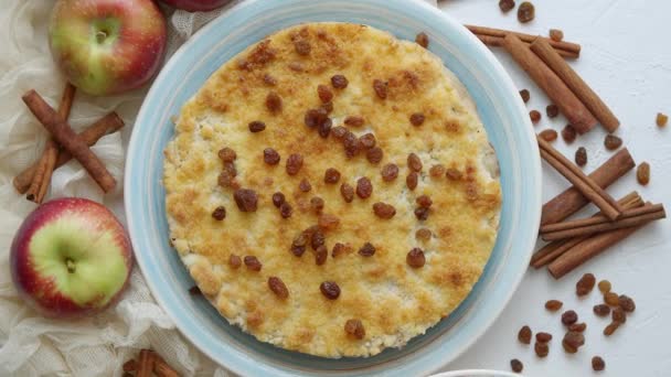 Domácí jablečný koláč na modrém keramickém talíři s čerstvými jablky a skořicovými tyčinkami — Stock video